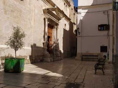 ...la cui facciata si staglia su un piccolissimo slargo punteggiato da panchine in ferro battuto